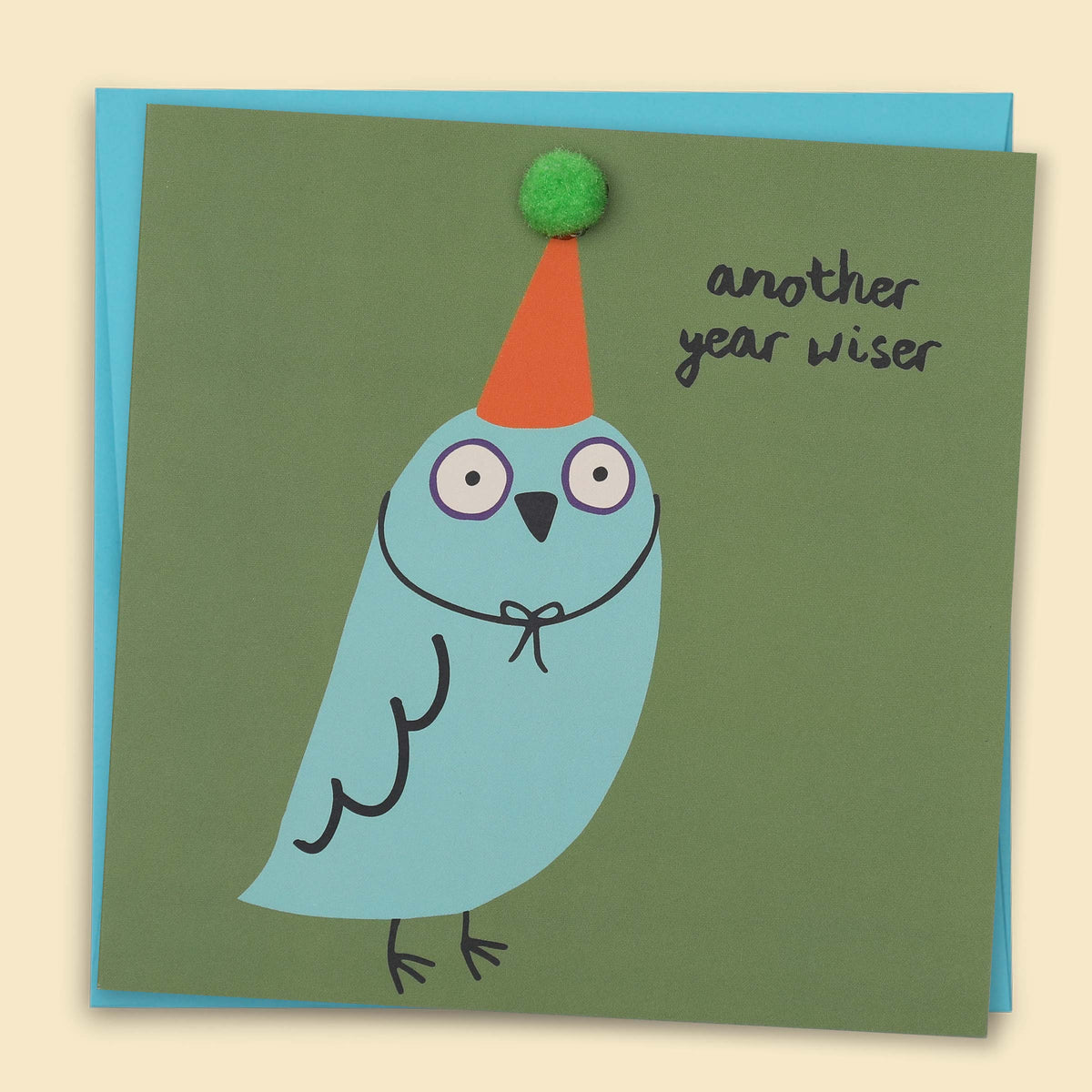 A blue bird wearing a party hat with small green pom-pom. and the text 'Another Year Wiser' — Australian-made greeting card by Papernest
