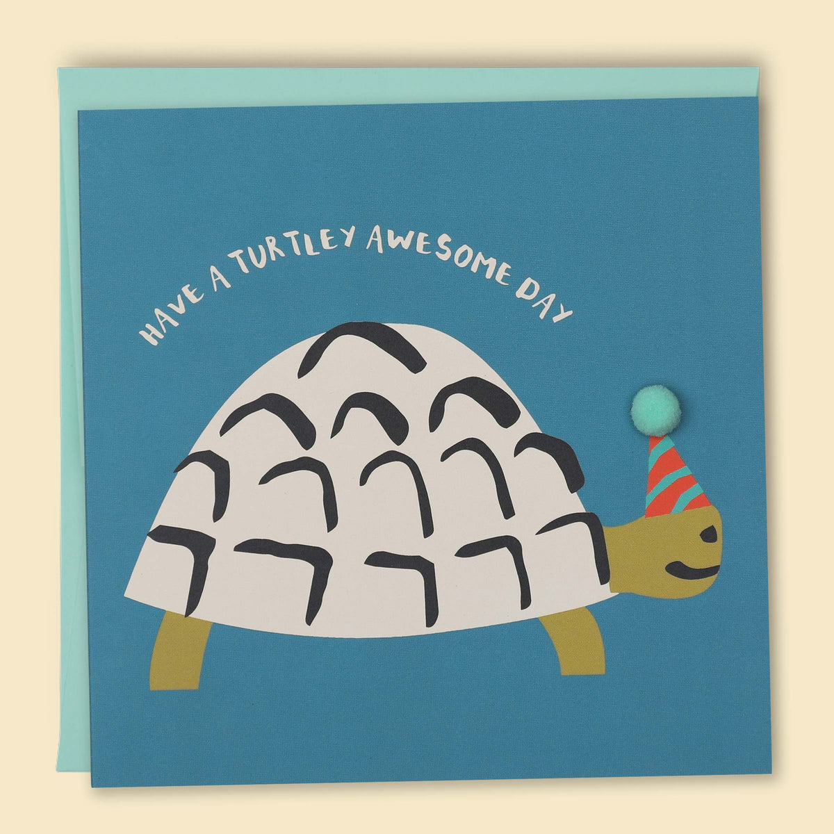 Greeting card with an illustration of a turtle wearing a party hat and balloon, with the text 'Have a Turtley AWESOME DAY!' The card is also decorated with a pom-pom detail — Australian-made greeting card by Papernest
